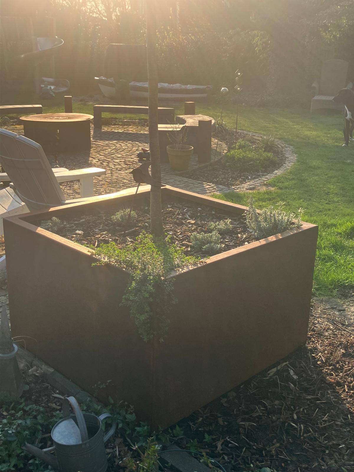 Ein Blumenkübel aus Metall, gefertigt quadratisch.