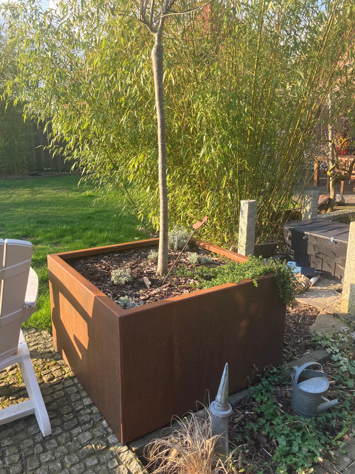 Aus Metall gefertigter Blumenkübel, quadratisch geformt